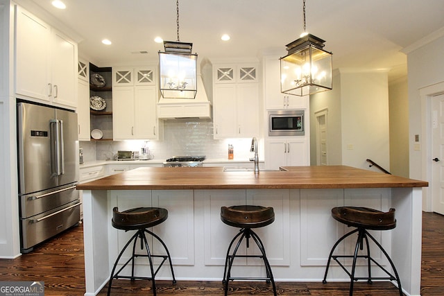 kitchen with open shelves, appliances with stainless steel finishes, dark wood-type flooring, and wood counters