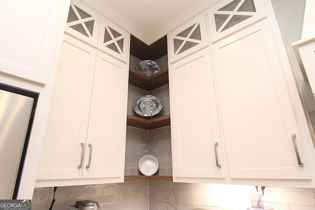 room details with glass insert cabinets, white cabinetry, and crown molding