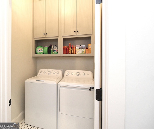 laundry room featuring baseboards, cabinet space, and washing machine and clothes dryer