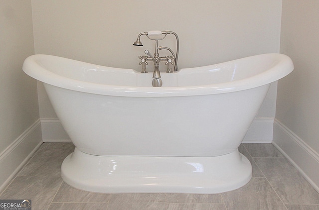 full bath with a freestanding tub and baseboards