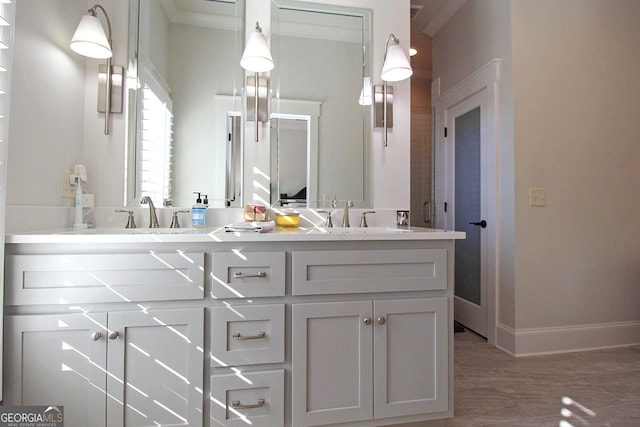 full bathroom featuring wood finished floors, a sink, baseboards, and double vanity