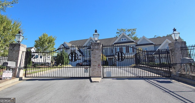 view of gate with fence and a residential view