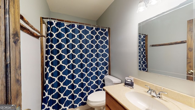 bathroom with toilet, a shower with shower curtain, and vanity