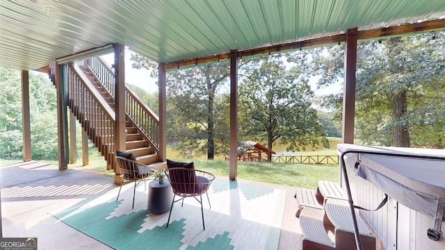 view of patio with stairs, fence, and a hot tub