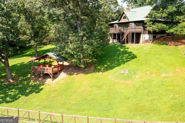 view of yard with fence, a deck, and a gazebo