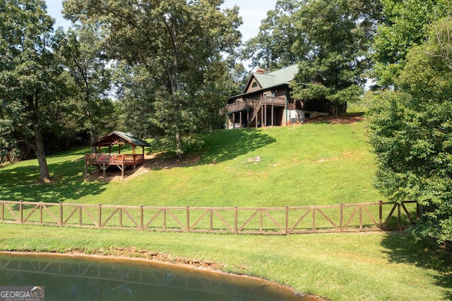 view of yard with a water view, fence, and a gazebo