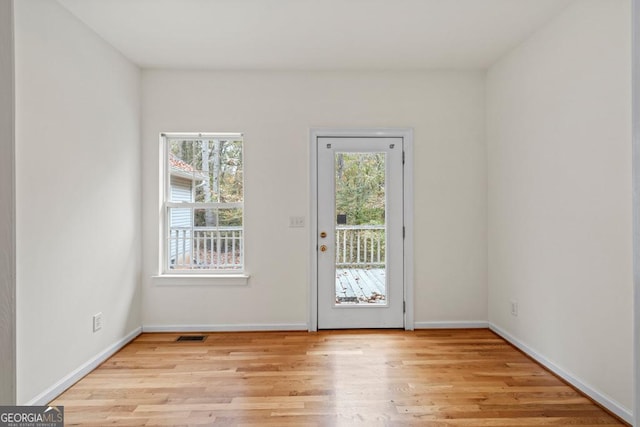 entryway featuring baseboards, visible vents, and light wood-type flooring