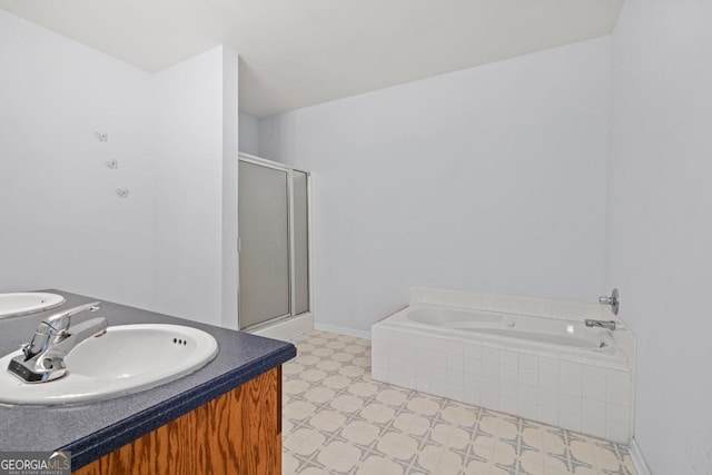 bathroom with a bath, a shower stall, vanity, tile patterned floors, and baseboards