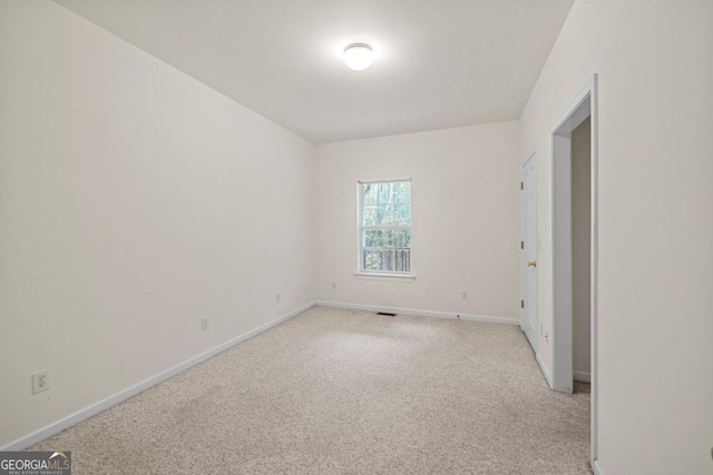 unfurnished room featuring light colored carpet and baseboards