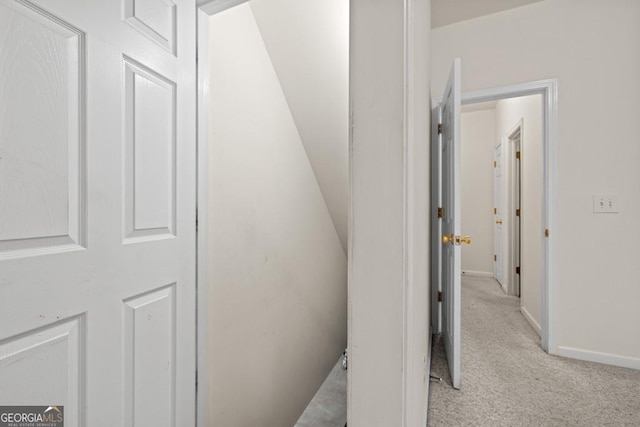 hall with light colored carpet and baseboards