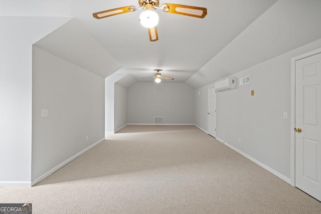 additional living space featuring light carpet, baseboards, visible vents, vaulted ceiling, and an AC wall unit