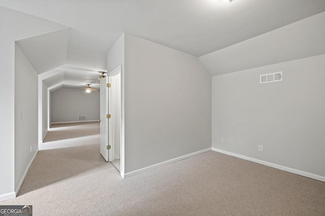 additional living space featuring lofted ceiling, baseboards, visible vents, and carpet flooring