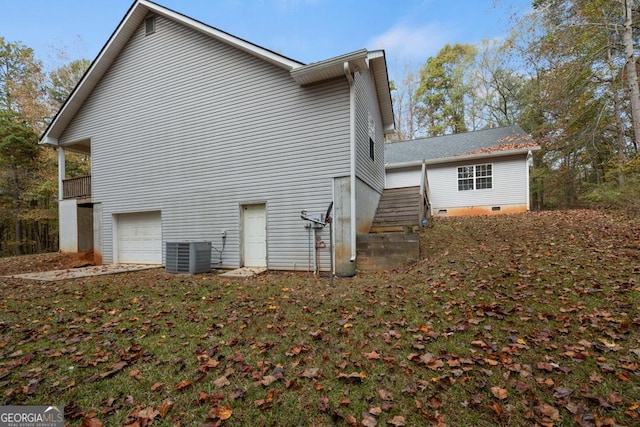 view of property exterior with an attached garage, central AC unit, and stairs