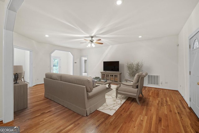 living area featuring visible vents, arched walkways, a ceiling fan, wood finished floors, and recessed lighting