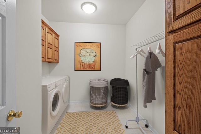 clothes washing area featuring cabinet space, light tile patterned floors, baseboards, and washer and clothes dryer