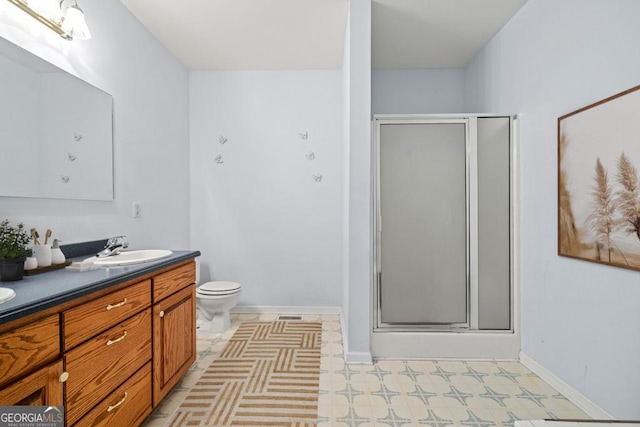 full bathroom with double vanity, a stall shower, toilet, tile patterned floors, and a sink