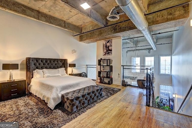 bedroom with a high ceiling, wood finished floors, and visible vents