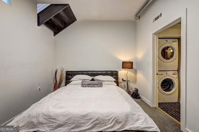 carpeted bedroom featuring visible vents and stacked washer / drying machine