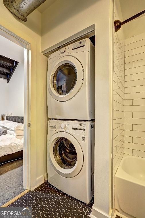 laundry room featuring stacked washer / dryer, laundry area, and baseboards