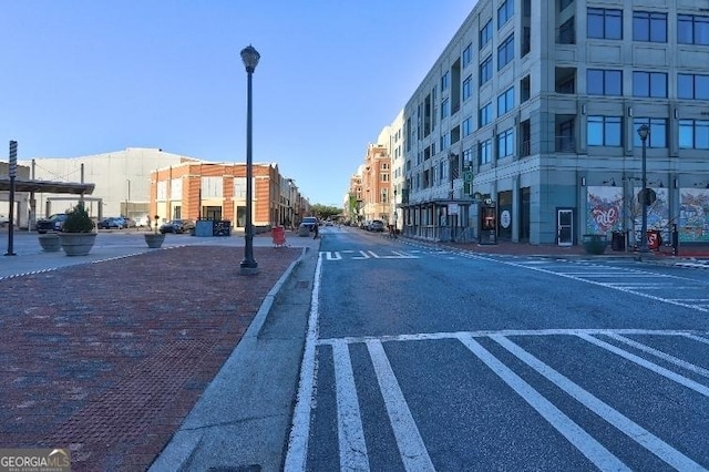 view of road featuring curbs, street lights, and sidewalks