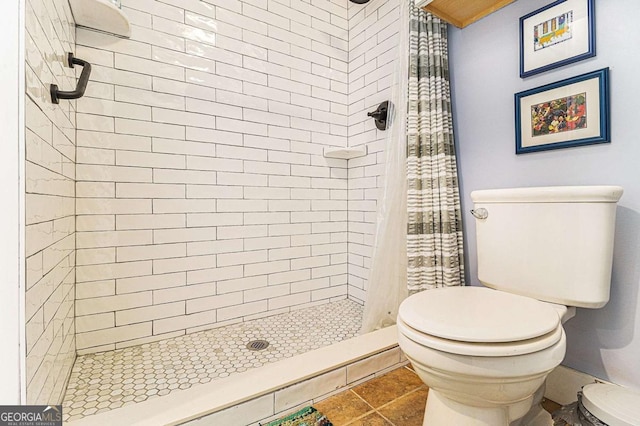 bathroom featuring a stall shower and toilet