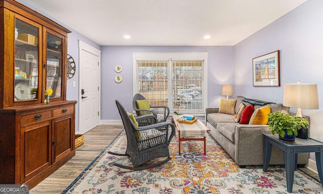 living area featuring baseboards, wood finished floors, and recessed lighting