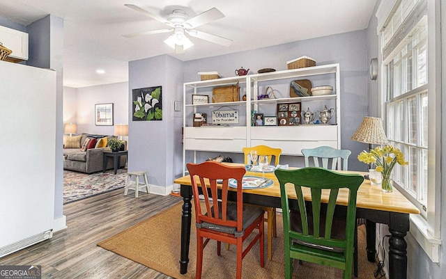 dining area featuring wood finished floors, a ceiling fan, and baseboards