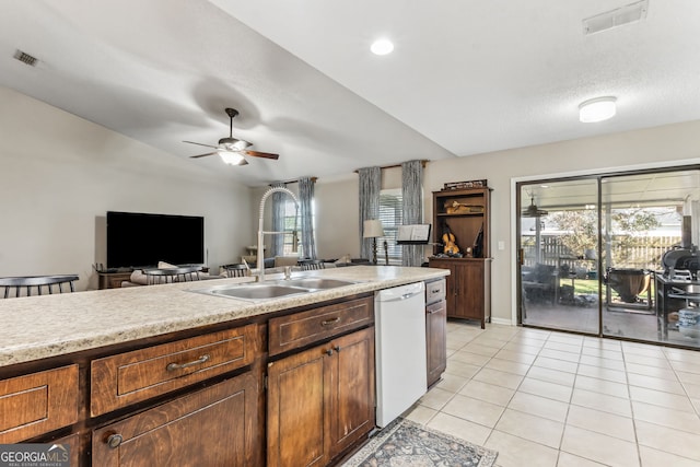 kitchen with light tile patterned floors, visible vents, white dishwasher, light countertops, and a sink