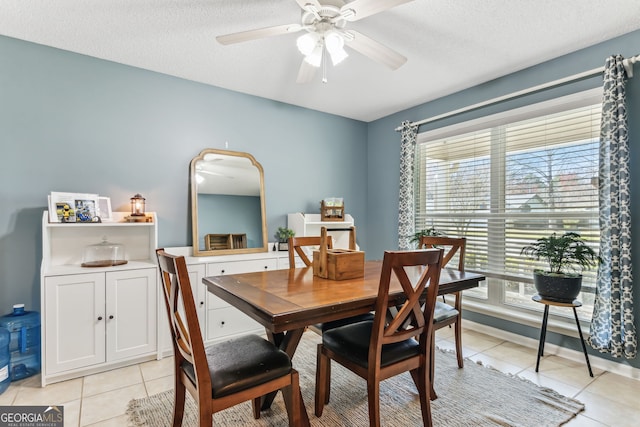 dining room with light tile patterned floors, ceiling fan, a textured ceiling, and baseboards