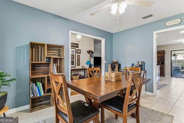 dining space with visible vents, ceiling fan, baseboards, and light tile patterned flooring