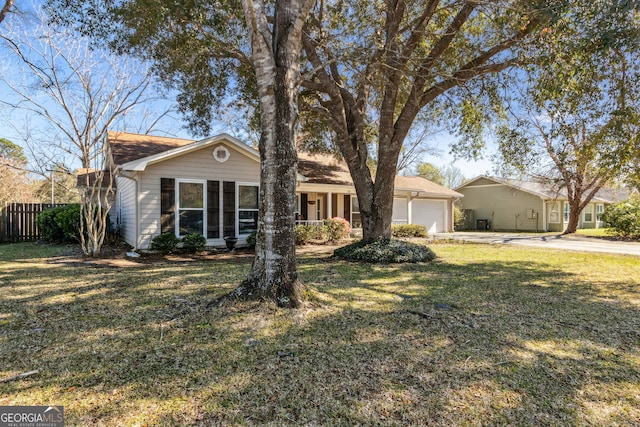 ranch-style house featuring concrete driveway, an attached garage, fence, and a front yard