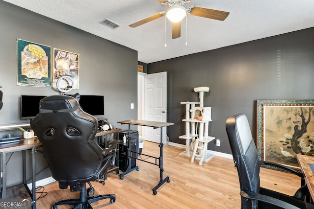 office area featuring baseboards, visible vents, a ceiling fan, wood finished floors, and a textured ceiling