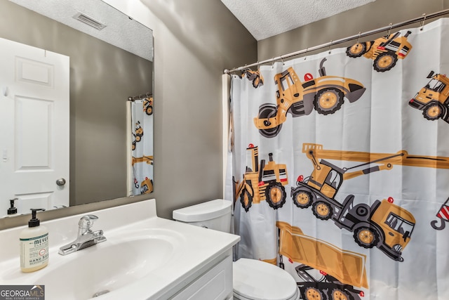 bathroom featuring a textured ceiling, curtained shower, toilet, vanity, and visible vents