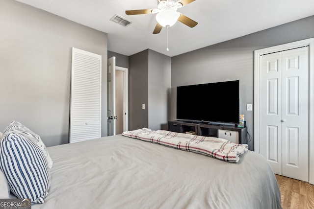 bedroom featuring ceiling fan, wood finished floors, and visible vents