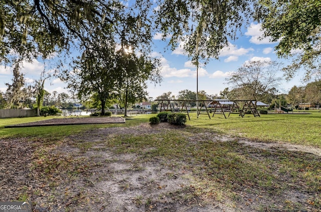 view of home's community with fence, a lawn, and playground community