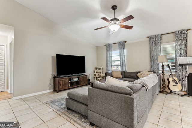 living room with light tile patterned floors, baseboards, vaulted ceiling, and a ceiling fan