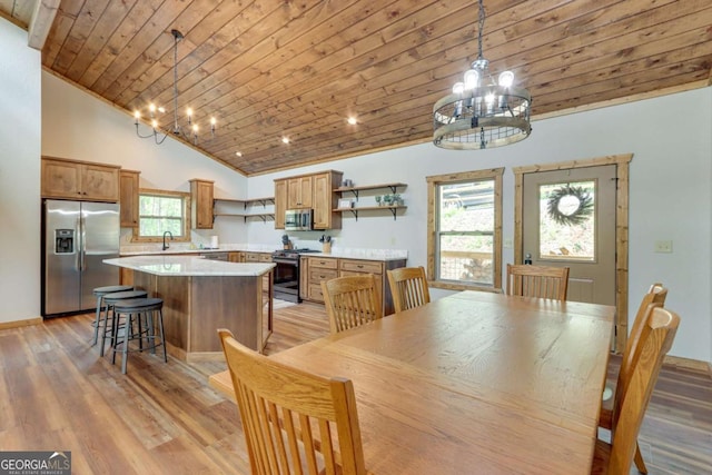dining area featuring wooden ceiling, plenty of natural light, a notable chandelier, and light wood-style floors