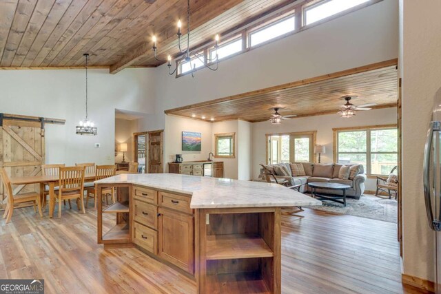 kitchen with a barn door, light wood-type flooring, open shelves, and wooden ceiling