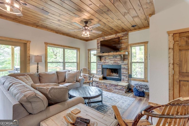 living area with a ceiling fan, wood ceiling, a fireplace, and wood finished floors