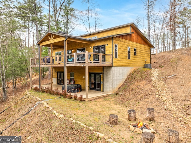 back of house with cooling unit, a deck, and french doors