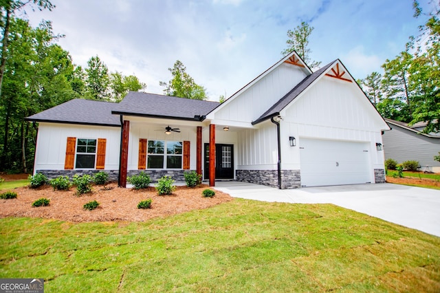 modern farmhouse style home featuring a garage, stone siding, board and batten siding, and a front yard