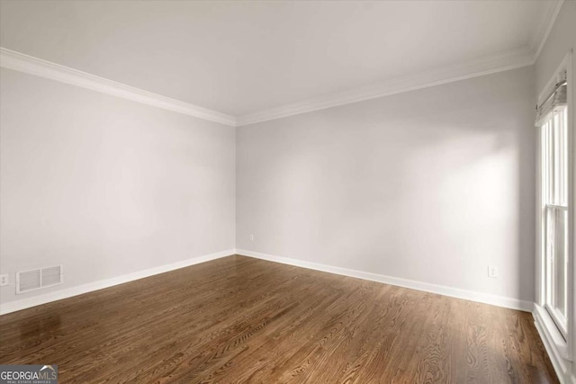 spare room with dark wood-style floors, baseboards, visible vents, and crown molding