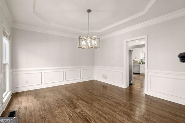 unfurnished dining area with a chandelier, ornamental molding, dark wood finished floors, and visible vents