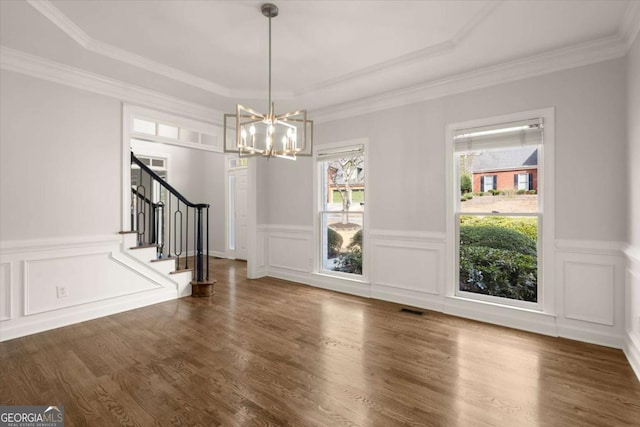 unfurnished dining area featuring ornamental molding, wood finished floors, visible vents, and stairs