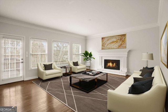 living area featuring ornamental molding, a brick fireplace, baseboards, and wood finished floors