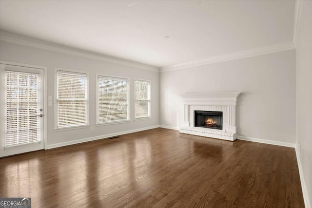 unfurnished living room featuring dark wood-style floors, a fireplace, baseboards, and crown molding