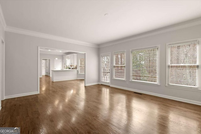 unfurnished living room featuring ornamental molding, dark wood-type flooring, and baseboards