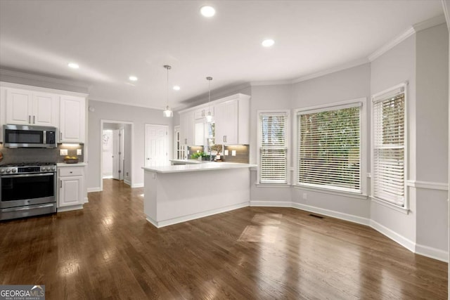 kitchen with stainless steel appliances, ornamental molding, white cabinetry, and decorative backsplash