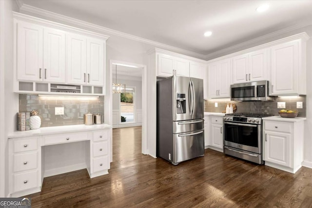 kitchen with dark wood finished floors, light countertops, appliances with stainless steel finishes, ornamental molding, and white cabinets