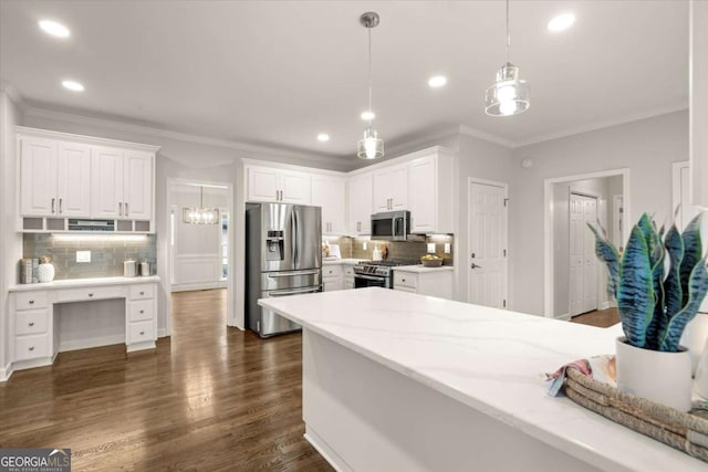 kitchen with pendant lighting, white cabinetry, appliances with stainless steel finishes, dark wood finished floors, and crown molding